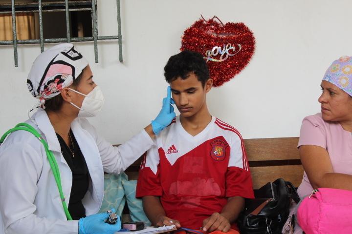 SAI (South American Initiative), a compassionate non-profit organization, delivers vital healthcare to orphaned children in Venezuela. In this image, a medical professional in a white coat carefully examines a child wearing a red and white sports jersey, ensuring they receive essential medical attention. Through generous donations and dedicated volunteers, SAI continues to support orphanages by providing free check-ups, medicine, and treatments, safeguarding the well-being of vulnerable children for a healthier future.
